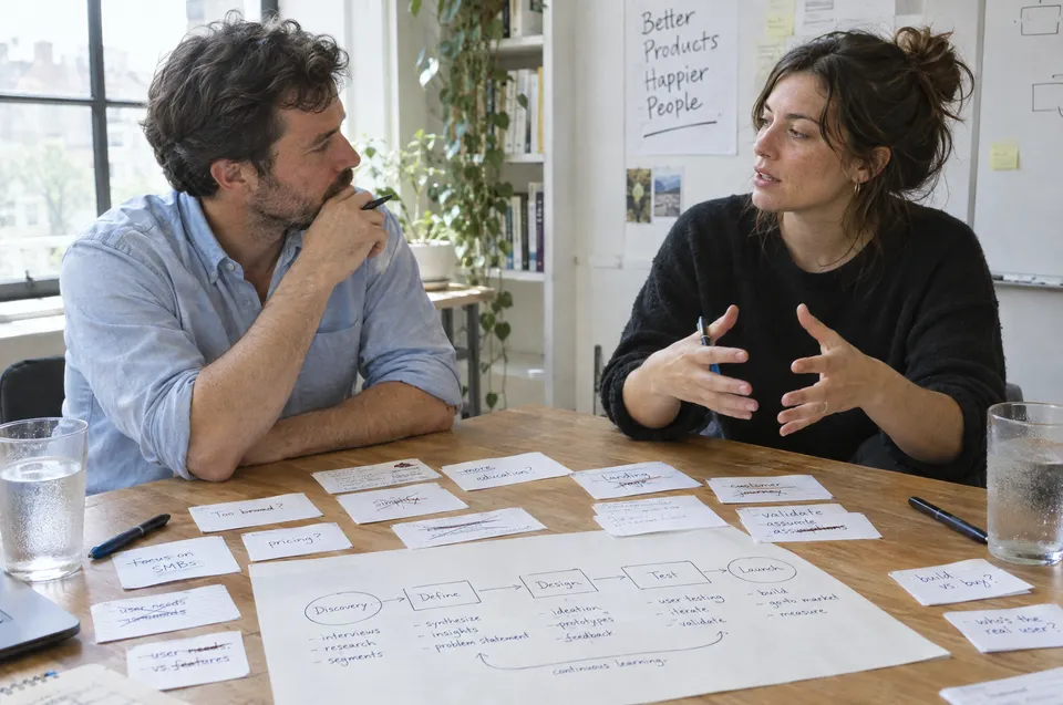 A consultant listens to a client explaining a process map during a discovery workshop.